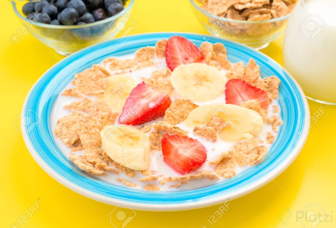 54673643-plato-de-cereal-con-leche-y-plátanos-fresas-fondo-amarillo.jpg